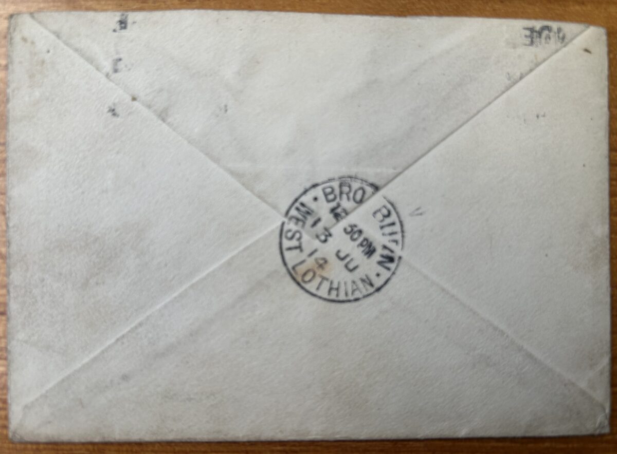 Reverse of a small envelope with triangular flap folds and a circular postmark reading “BROXBURN, WEST LOTHIAN” dated 13 June 1914. The envelope is lightly worn and discoloured with age, and the postmark confirms its arrival in Broxburn following posting from Dundee.
