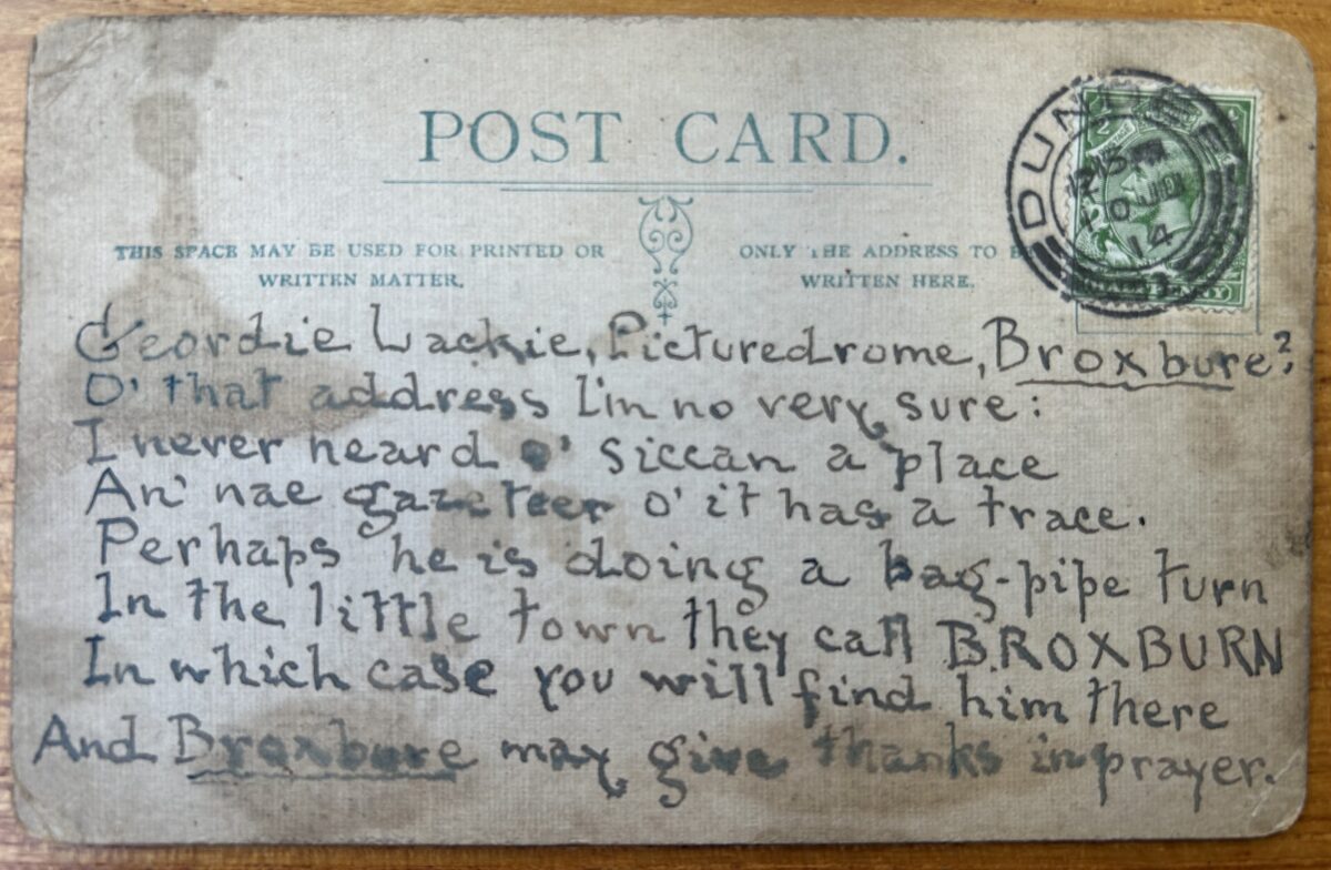 Reverse of a worn postcard with a green King George V halfpenny stamp and postal mark. Handwritten in ink, the card is addressed to “Geordie Lackie, Picturedrome, Broxbure?” and contains a humorous Scots verse joking about the recipient’s whereabouts and the town of Broxburn.