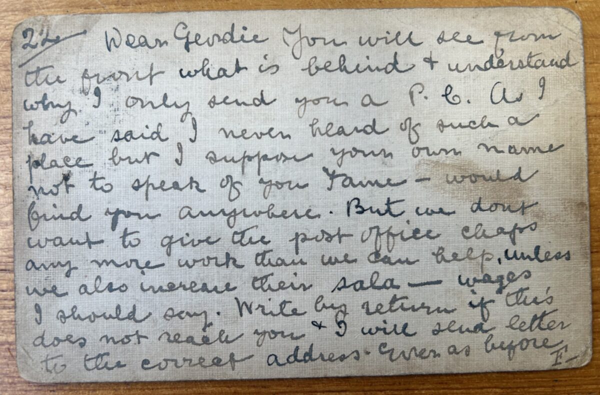 Reverse of a worn early twentieth-century postcard covered with a handwritten message in dark ink. The letter is addressed to “Dear Geordie” and jokes about the unusual address “Picturedrome, Broxburn,” discussing the challenge of sending mail and trusting the recipient’s reputation to ensure delivery. The postcard shows signs of age, including stains, fading, and rounded corners.