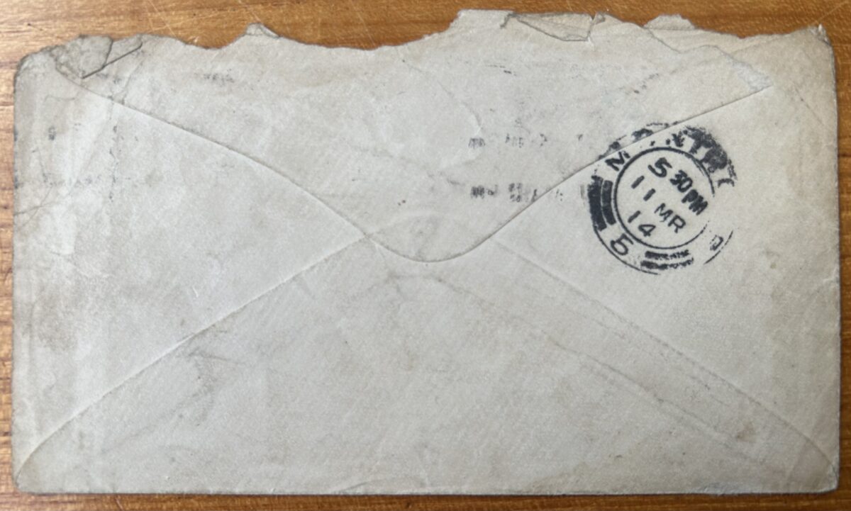 Reverse of a worn envelope addressed to entertainer Geordie Lackie. The envelope is sealed with a triangular flap and bears a circular Montrose postmark dated 11 March 1914. The paper is creased, torn along the edges, and discoloured with age.