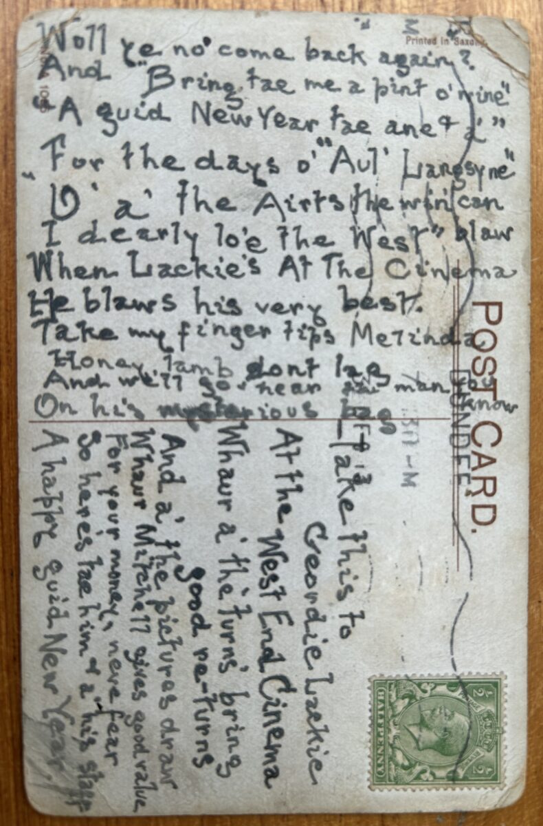 Handwritten New Year postcard with dense Scottish dialect verse and a green King George V halfpenny stamp. The message is addressed to “Geordie Lackie” at Dundee’s West End Cinema and contains festive wishes for the New Year.